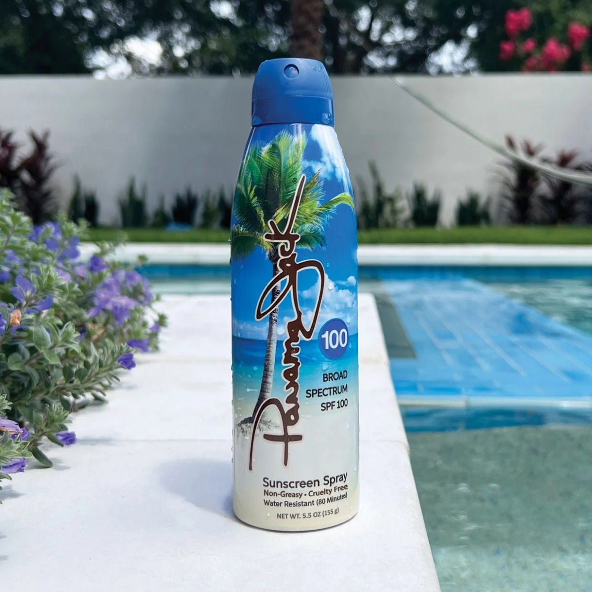 Panama Jack sunscreen spray bottle with palm tree design by a poolside
