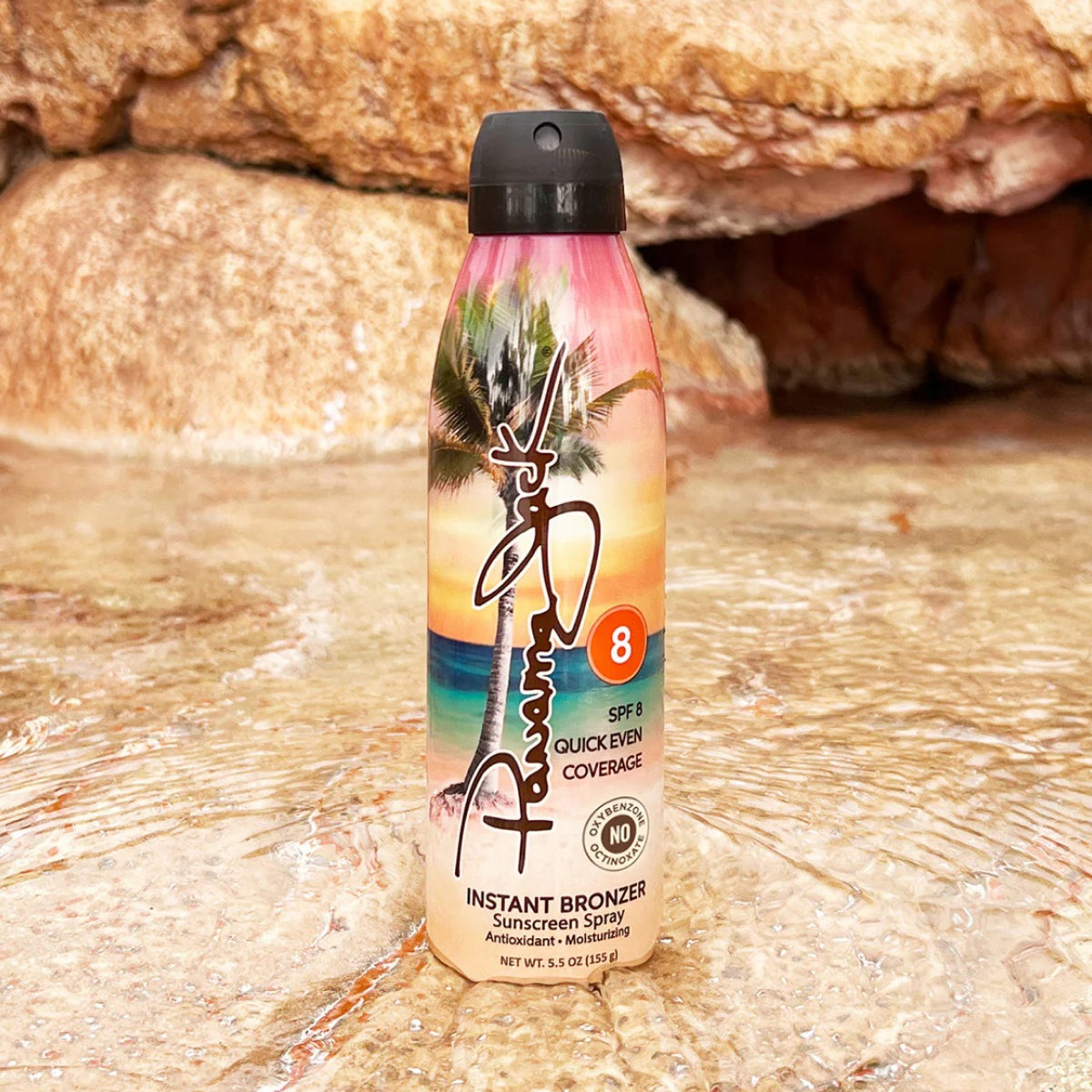 Sunscreen spray bottle with tropical design on a rocky surface