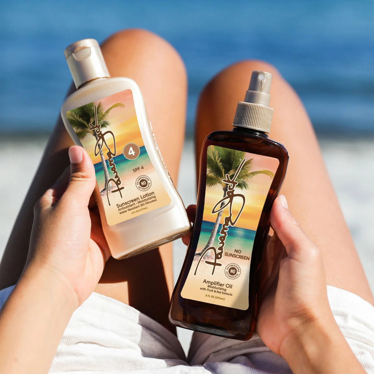 Two sunscreen products held by a person sitting on a beach.