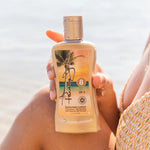 Person holding a Panama Jack sunscreen lotion bottle with a beach background
