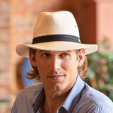Man wearing a straw Panama Jack hat with a black band outdoors