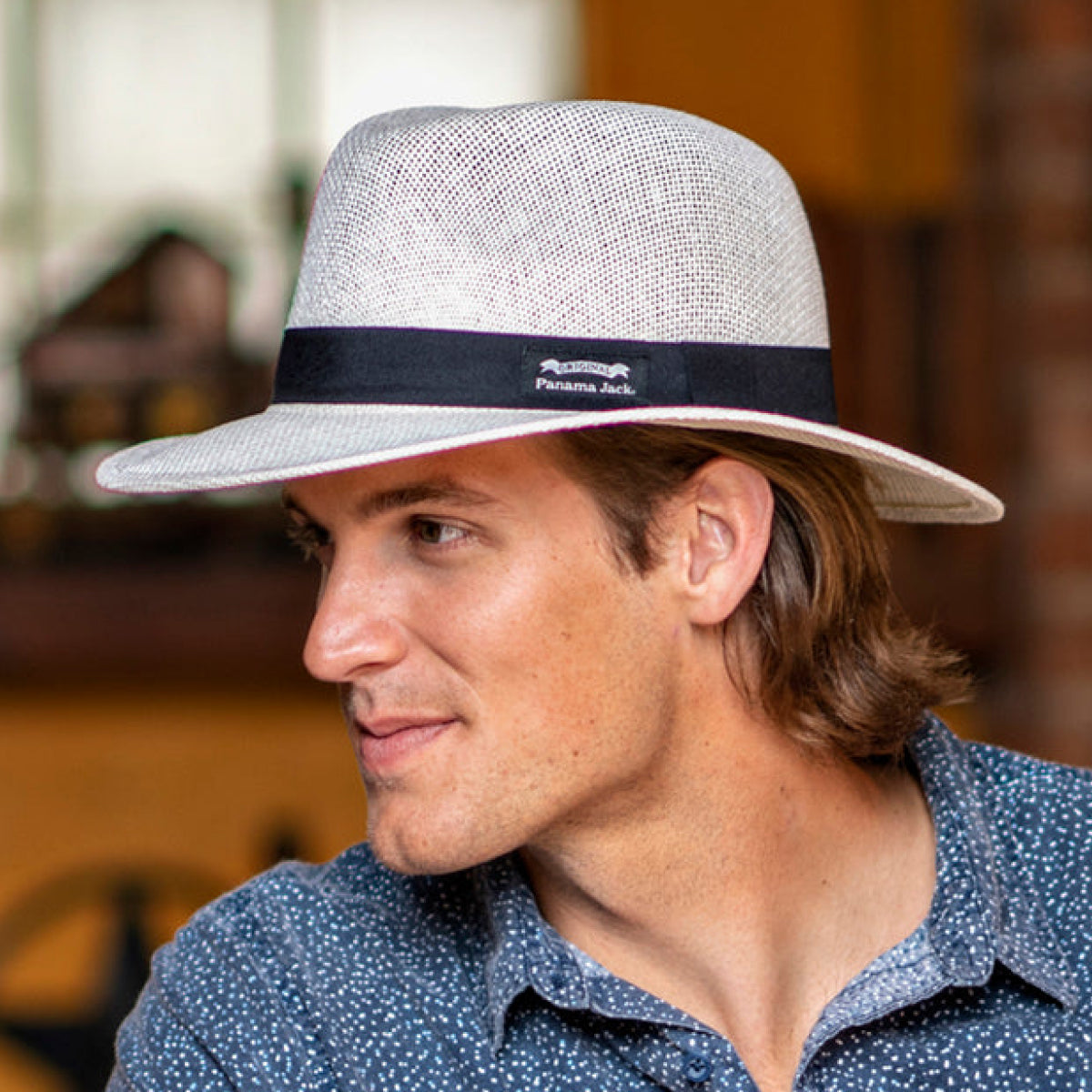 Man wearing a Panama Jack hat with a blurred background