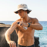 Man applying Panama Jack sunscreen on a beach with ocean view