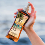 Hand holding a bottle of Panama Jack Sunscreen Oil with a scenic label against a blurred background