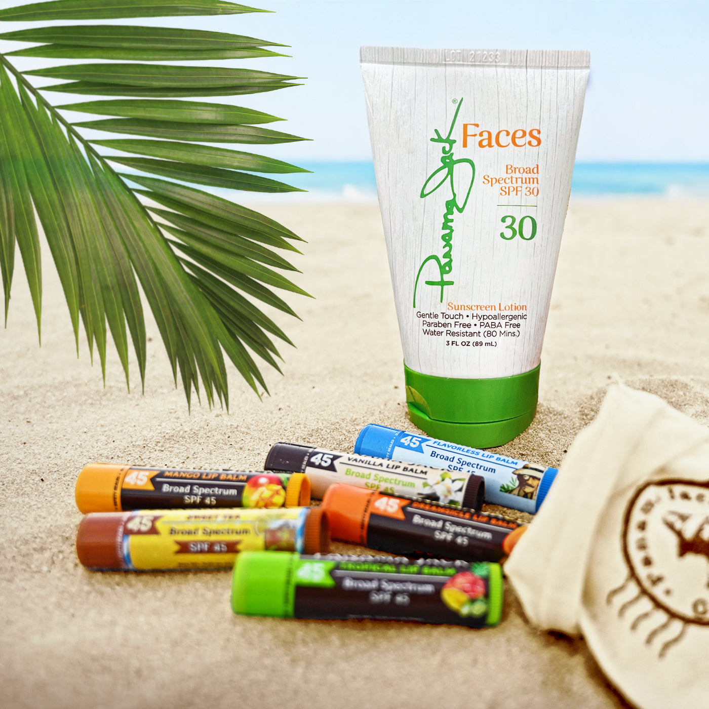 Panama Jack Fragrance-free sunscreen lotion with applicators on sand, palm leaf in background
