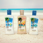 Three Panama Jack bottles of sunscreen lotion standing on a sandy beach with the ocean in the background. The left bottle is white with a blue cap and SPF 30 label, the middle bottle is beige with a gold cap and SPF 8 label, and the right bottle is white with a blue cap and SPF 50 label.