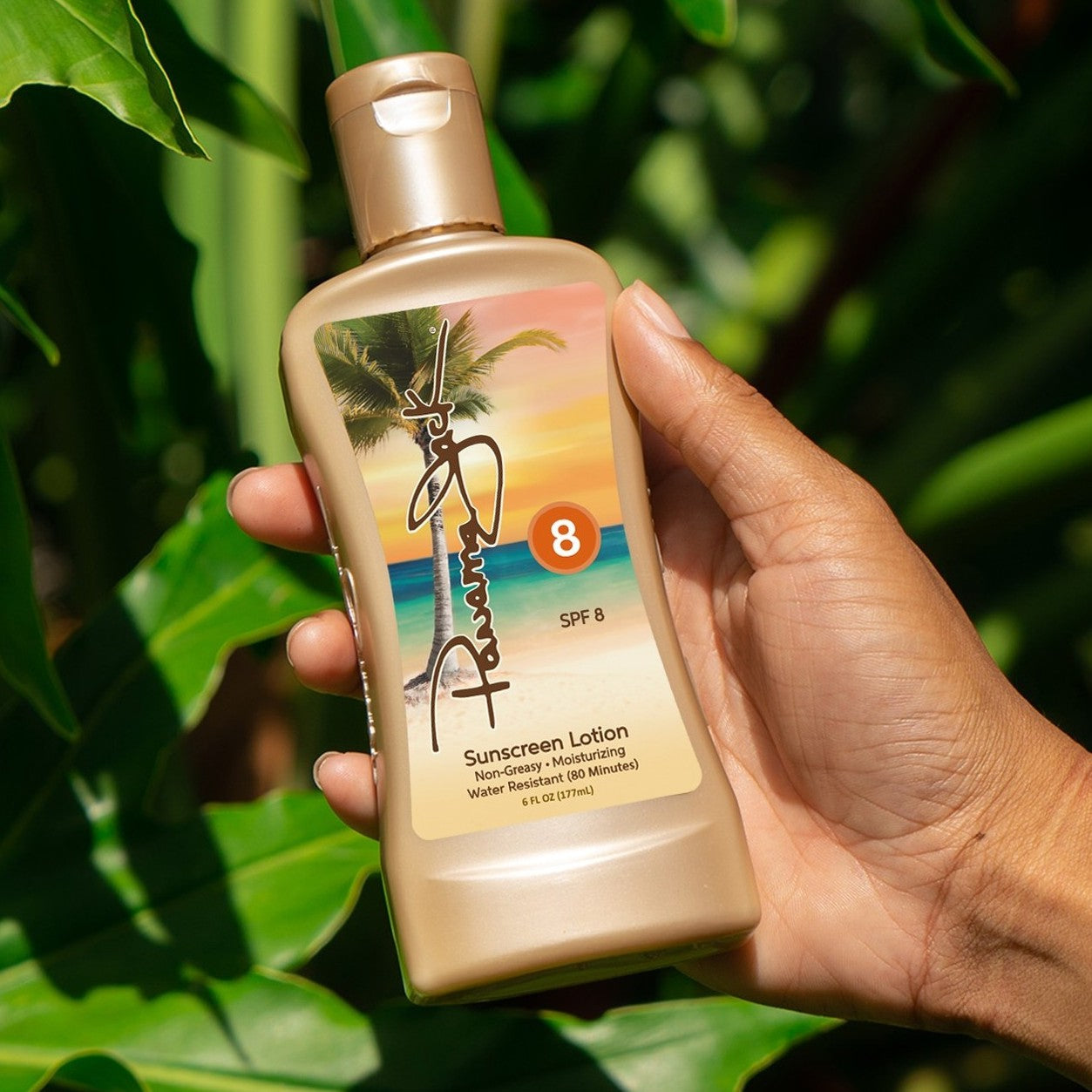 Hand holding a Panama Jack SPF 8 sunscreen lotion bottle with a tropical design against a green leafy background