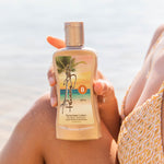 Person holding a Panama Jack sunscreen lotion bottle with a beach background