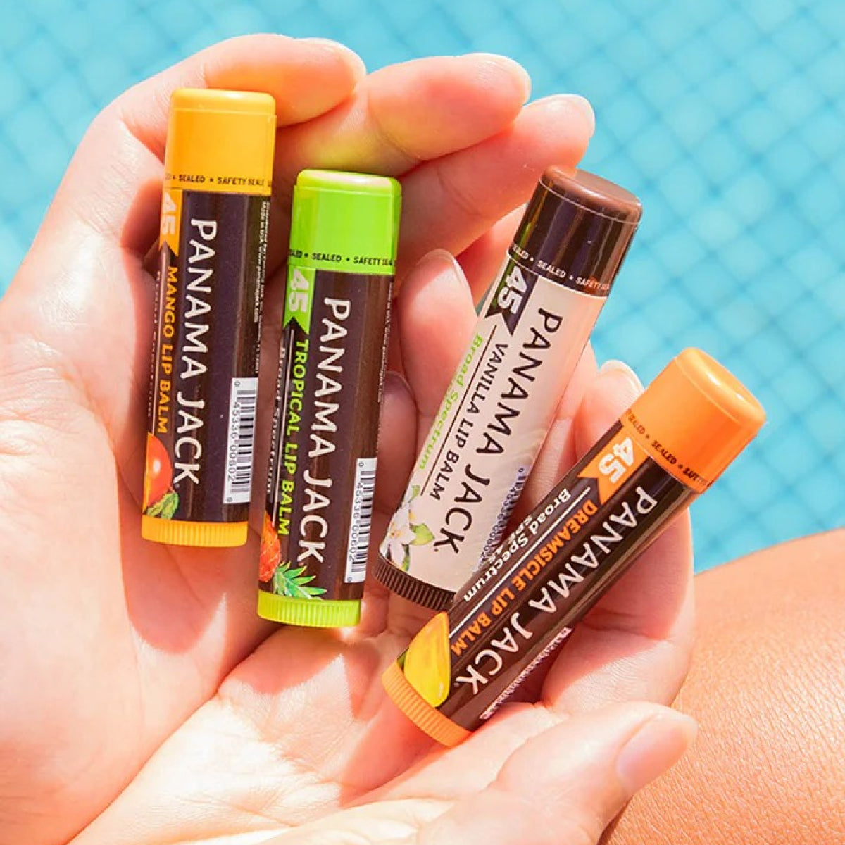 Hand holding four Panama Jack lip balms with a blue background