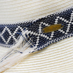 Close-up of a Panama Jack straw hat with a blue and white patterned band and a brand logo.