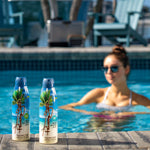 Two Panama Jack sunscreen bottles on a ledge by a pool with a woman in the background