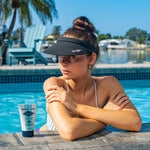 Woman relaxing by a pool with a bottle of Panama Jack sunscreen in the foreground