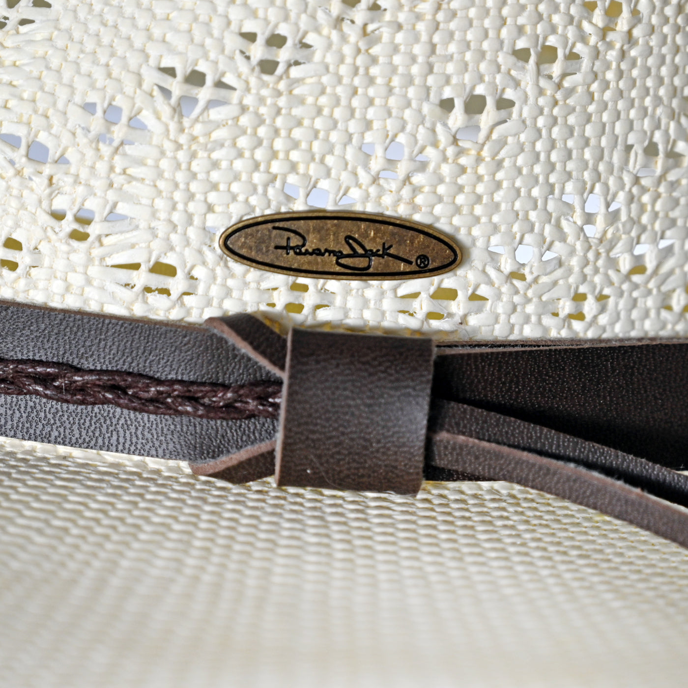 Close-up of a woven Panama Jack hat with a leather band and brand logo.