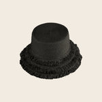 Black straw Panama Jack hat with frayed edges on a beige background