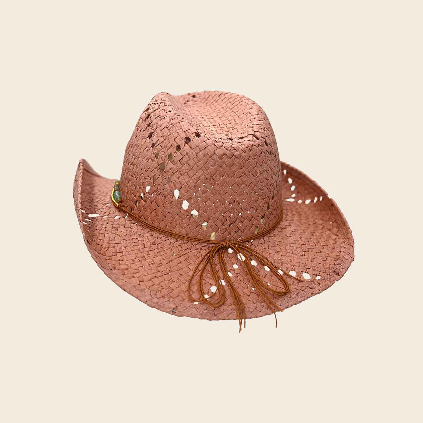 Pink straw Panama Jack hat with a brown ribbon on a beige background