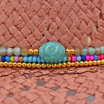Panama Jack Colorful beaded bracelet with a turquoise stone on a woven surface