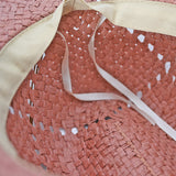 Close-up of a pink straw Panama Jack hat with a beige ribbon