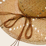 Close-up of a straw Panama Jack hat with a brown ribbon on a light background